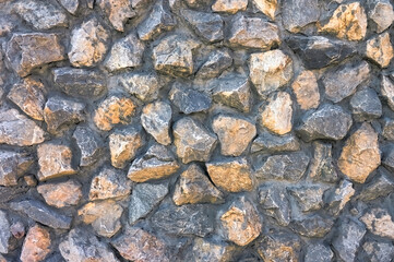 Texture of concrete wall with granite rubble close-up.
