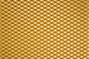 Fototapeta premium Gold beeswax for candle, texture. Honeycomb background from a bee hive. 