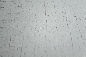 Jigsaw puzzle. Closeup of the cardboard background of jigsaw puzzle peices. Conceptual photo with focus on completed puzzle