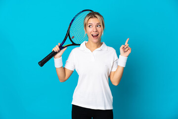 Young Russian woman isolated on blue background playing tennis and pointing up