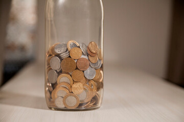 Pot with real currency, money from Brazil. Coins in the pot on the table. Brazilian economy, investments, income. Brazilian currency concept. Piggy bank concept.
