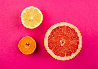 Fototapeta na wymiar Citrus slices on pink background