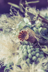 Close-up of a wreath of dried flowers in light green and white winter colors, vintage style, vertical