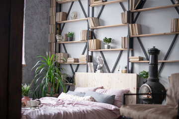 Fototapeta na wymiar Home library on open shelves in a trendy, stylish loft-style bedroom.