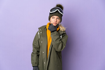 Skier Russian girl with snowboarding glasses isolated on purple background having doubts