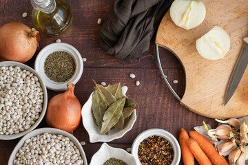 Traditional cuisine - raw beans and seasoning on wooden background