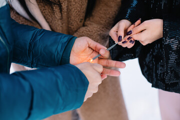People in cold weather set fire to sparklers Man and two women in winter jackets