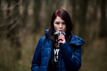 Vape teenager. Young pretty caucasian brunette girl with problem skin smoking an electronic...