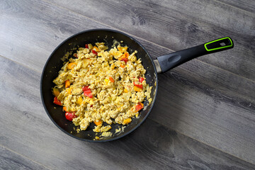 Scramble in a frying pan on a gray table background, delicious fresh and delicious dinner