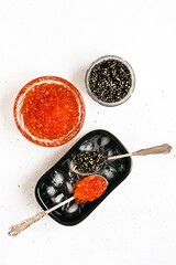 Black and red fish caviar on a white background.