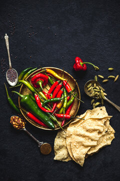 Indian cooking ingredients: chilli peppers, cardamom, black mustard seeds, poppadoms