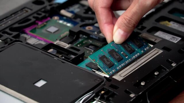 Laptop repair engineer (PC computer) and motherboard install RAM in computer lab top.