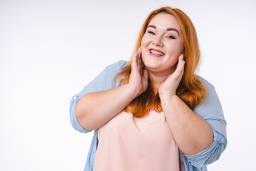 Touched by a compliment plus size redhead woman isolated over white