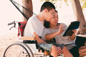 Special need child on wheelchair use a tablet in the house with his parent, Study or Work at home...