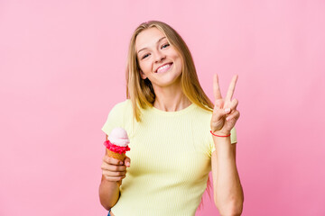 Young russian woman eating an ice cream isolated showing number two with fingers.