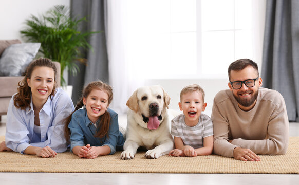 Happy Idyllic Family With Kids And Dog Resting At Home