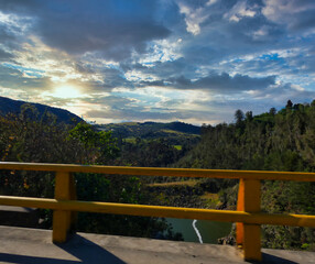 Sol descendente del atardecer en el valle bajo un puente