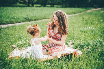 Mother and daughter enjoying picnic and eating pizza in the park.