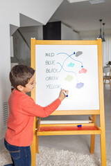 Little boy learning english on a blackboard at home