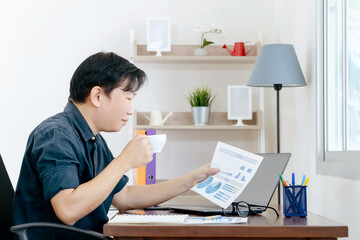 A businessman is reading a monthly sales graph in his home.