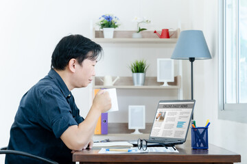 Businessman Checking Online News On Laptop with coffee in the morning
