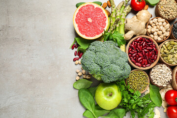 Flat lay composition with different vegetables, seeds and fruits on grey table, space for text. Healthy diet