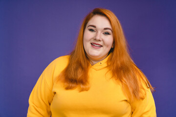 Portrait of a plump redhead woman isolated over blue background