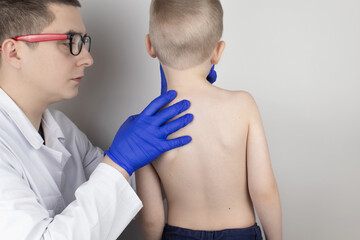 A little boy at the doctor's appointment with back pain. Treatment of spinal deformity and stoop....