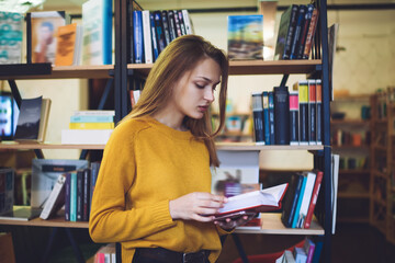 Young woman reading book in library