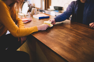 Crop woman taking cup of coffee