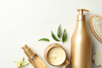 Flat lay composition with hair cosmetic products on white wooden table