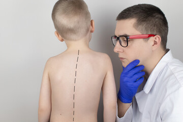 A little boy at the doctor's appointment with back pain. Treatment of spinal deformity and stoop....
