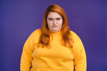 Offended plus size woman isolated over blue background