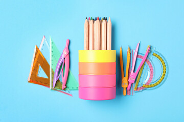 Different stationery on light blue background, flat lay. Back to school