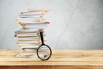 File folders with documents and magnifying glass on the desk