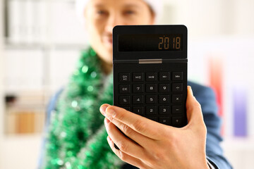 Man in suit hold in arm calculator with 2018 year symbol in office closeup