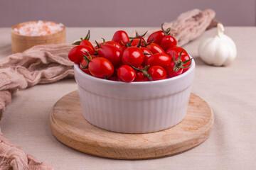 Fermented red cherry tomatoes in a white plate. Vegetarian food. Salted tomatoes. Pickled organic tomatoes. Homemade fermented foods. Food stocks.