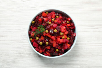 Traditional Russian salad vinaigrette on white wooden table, top view