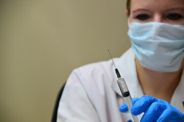 Doctor, nurse, scientist hand in blue gloves holding flu, measles, coronavirus, covid-19 vaccine disease preparing for child, baby, adult, man and woman vaccination shot, medicine and drug concept.