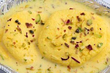 Indian Bengali Chhena Mithai Rasmalai Also Known As Rossomalai Roshmolai Rasamalei Ras Malai Made Of Fresh Curdled Milk Pista Meetha Doodh And Kesar. Soaked In Cream Milk