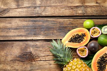 Fresh ripe papaya and other fruits on wooden table, flat lay. Space for text