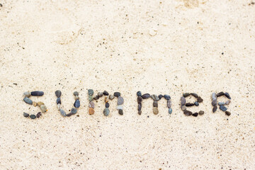 Wurd summer on the sand made from stones. Holiday and vacation concept.
