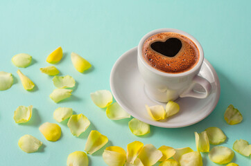 Cup coffee and petals roses on table. Mother's day breakfast
