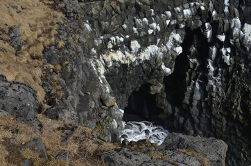 Basalt Column Rocks Along a Cavern and Beach of Iceland