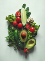 Fresh vegetables avocado, cucumber, lettuce, spinach, dill, tomatoes and garlic on a white background