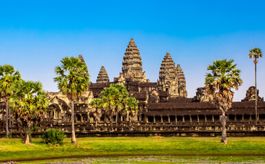 Naklejka premium Beautiful landscape of the ancient city of Angkor Wat in Cambodia. Towers of the temple of the Kmer people with reflection in the lake. The concept of travel to the sights of ancient civilizations.