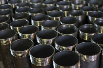 Steel pipes with threads in a production warehouse. Close-up