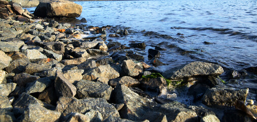 Pebble stone shore on lake zurich with water