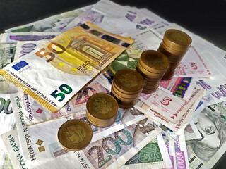 Closeup of Czech coins placed on different euro banknotes in different columns, Czech, Euro, Croatia, photo