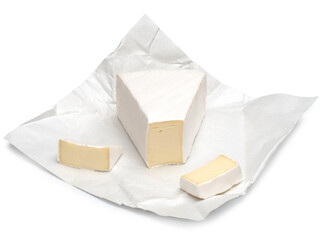 Brie cheese chunks on wrapping paper isolated on a white background